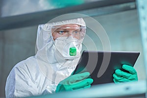 Virologist healthcare professional using tablet computer in laboratory