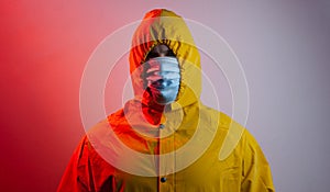 Virologist in a medical mask and yellow protective suit with a hood