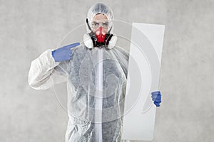 Virologist in protective clothing holds advertising space in his hands