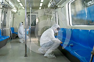 Virologists staff in hazmat suits cleaning disinfecting covid-19 in subway or sky train