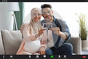 Virtual Announcement. Muslim Couple Showing Baby Ultrasound To Family Via Video Call