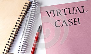 VIRTUAL CASH word on the pink paper with office tools on white background