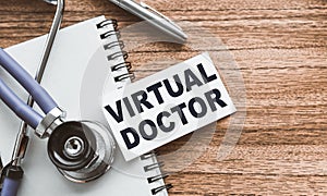 VIRTUAL DOCTOR - text on business card on wooden table with stethoscope and card for medical records. Medical concept