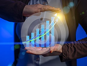 Virtual hologram of growth financial chart with increase arrow in businessman hands