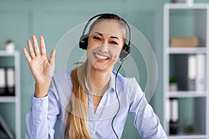 Virtual meeting. Happy businesswoman in headset making video call and waving hand wo webcamera