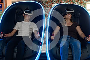Virtual reality attraction, son and mother experience adrenaline from virtual reality.