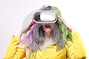 Virtual Reality Concepts. Portrait of caucasian Girl With Curly Colorful Hair Playing With VR Virtual Reality Helmet