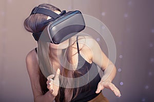 Virtual reality and the digital world of gadgets and video games. Girl gamer in VR glasses.Concept of the future