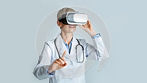 Virtual training for medical workers. Woman doctor in virtual reality glasses points finger