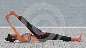 Virtual Woman in Yoga Reclining Hand to big Toe Pose with a clear wood floor