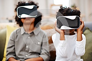 The virtual world is so cool. two little boys watching movies together through virtual reality headsets at home.