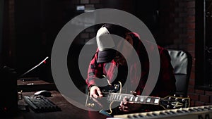 Virtuoso guitarist wearing cap and glasses enjoying performing favorite music playing on guitar.