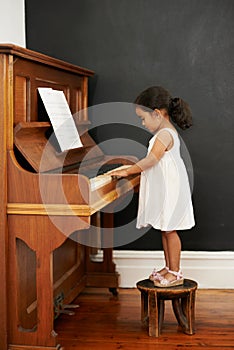 Virtuoso in the making. a little girl playing the piano.