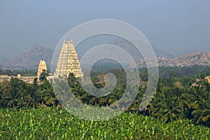 Virupaksha Temple among mountains and palm plantations on sunrise