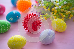 Virus model of Coronavirus disease COVID-19 with colorful easter eggs with flowers on a pink wooden table background