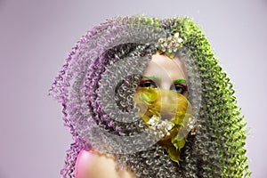 Virus Protection Ideas. Portrait of Positive Caucasian Girl With Frizzy Colorful Hair and Flowery Facial Protective Mask