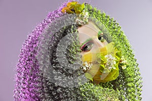 Virus Protection Ideas. Portrait of Positive Caucasian Girl With Frizzy Colorful Hair and Flowery Facial Protective Mask