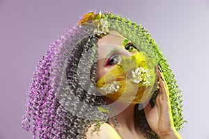 Virus Protection Ideas. Portrait of Positive Caucasian Girl With Frizzy Colorful Hair and Flowery Facial Protective Mask