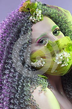 Virus Protection Ideas. Portrait of Positive Caucasian Girl With Frizzy Colorful Hair and Flowery Facial Protective Mask