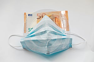 Virus protection mask against pandemic of coronavirus COVID-19. Dirty money banknote