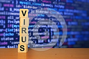 Virus text on wooden cube blocks with blue software developer code screen in background. Coronavirus background. Work from home