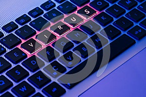 Virus written in red on a backlit keyboard in a blue ambiant light