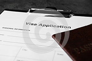 Visa application form for immigration and passport on grey table, closeup