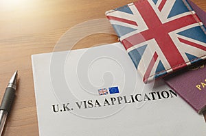 Visa application for uk on desktop with passport and union jack wallet