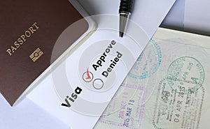 Visa and passport to approved stamped on a document top view in