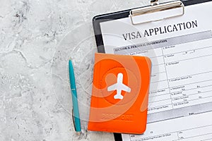 Visa prosessing. Registration of visas. Visa application form, pen, passport cover with airplane silhouette on grey