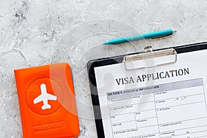 Visa prosessing. Registration of visas. Visa application form, pen, passport cover with airplane silhouette on grey