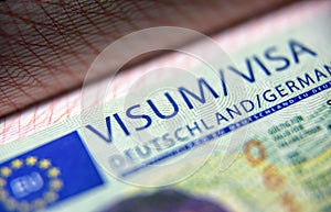 Visa stamp in passport close-up. German visitor visa at border control. Macro view of Schengen visa for tourism and travel in EU