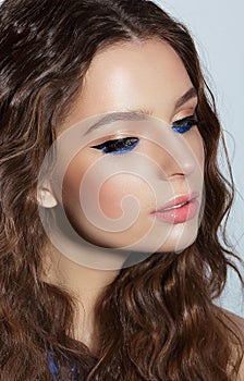 Visage. Pensive Woman with Blue Mascara and Holiday Makeup