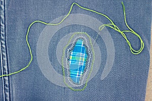 Visible mending on jeans, creative sustainable fashion