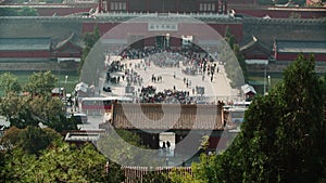 Visible smog above Beijing and tourists trying to sightseeing the Forbidden City