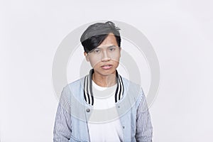 A visibly upset Filipino man looking disappointed at the camera. Isolated on a white background