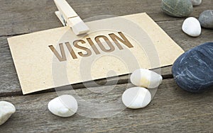 Vision, business conceptual words with wooden background with brown paper sheets or note.