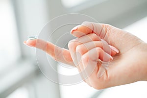 Vision Contact Lenses. Woman holds finger on a contact lens, closeup