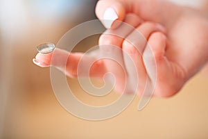 Vision Contact Lenses. Woman holds finger on a contact lens, closeup