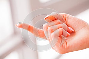 Vision Contact Lenses. Woman holds finger on a contact lens, closeup