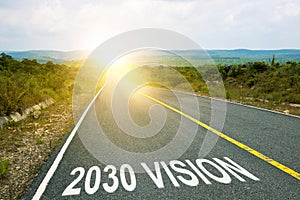 2030 vision inscription on straight road. Sunny morning landscape. Motivational inscription on the road going forward. The