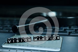 Vision Mission text wooden blocks in laptop background. Business and technology concept