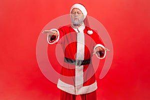 Vision problems. Portrait of blind disoriented lonely elderly man in santa claus costume walking