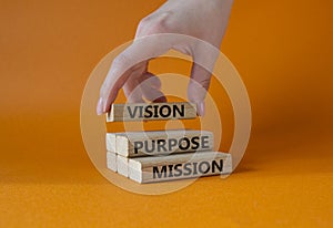 Vision Purpose Mission symbol. Concept word Vision Purpose Mission on wooden blocks. Beautiful orange background. Businessman hand