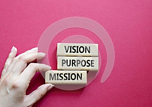 Vision Purpose Mission symbol. Concept word Vision Purpose Mission on wooden blocks. Beautiful red background. Businessman hand.