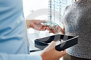 Vision, sight and treatment by an optometrist giving a woman a pair of glasses. Closeup of a female buying spectacles to