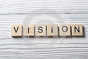 VISION word on wood abc cubes at wooden background.