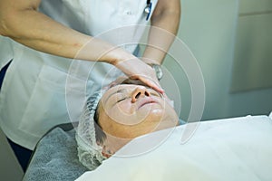 A visit to a beautician. Doctor beautician prepares the patient`s face for the procedure - carboxytherapy. The preparatory stage