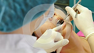 Visit to dentist. female dentist examining and working on patients teeth, close-up. Top view. Young woman getting dental