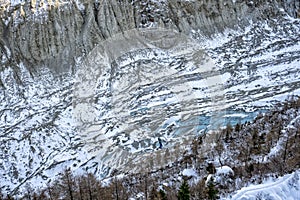 Visiters enterning ice cave under massive glacier near Chamonix in French Alps